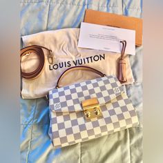 This Louis Vuitton Croisette Bag Is A Stylish And Functional Accessory For Women. It Features A Snap Closure, Brown Leather Handle With A 3-Inch Drop, And Gold Hardware. The Bag Is Made Of White Canvas With A Coated Finish And Adorned With The Iconic Louis Vuitton Damier Azur Pattern. The Bag Measures 9 Inches In Width, 6.5 Inches In Height, And 3.5 Inches In Depth. The Interior Is Lined With Pink Fabric And Features Enough Space For All Your Essentials. This Shoulder Bag Is A Perfect Addition T Lui Viton, Louis Vuitton Croisette, Louis Vuitton Damier Azur, Functional Accessories, Pink Fabric, White Canvas, Louis Vuitton Damier, Leather Handle, Women Collection