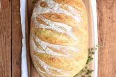 a loaf of bread sitting on top of a wooden cutting board