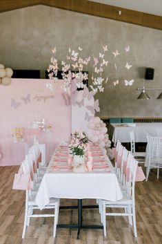 a table set up for a party with pink and white decorations