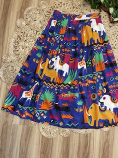 "Love this one so bright and cheerful. 80's Safari print midi skirt by Batya. Buttons on the side. Pockets at the hips. Bold colorful elephants, giraffes and antelope print. Purple, gold, black, green, and orange. Such a fun piece. In good vintage condition. Measurements taken while item was laying flat. Waist: 15\" Length: 35.5\"" Antelope Print, Colorful Giraffe, Ginger Dress, Harlequin Pattern, Colorful Elephant, Lafayette La, Safari Print, Printed Midi Skirt, Chambray Dress