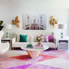 a living room filled with white furniture and lots of colorful pillows on top of it