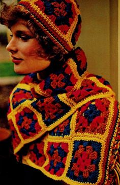 a woman wearing a colorful crocheted shawl and hat with flowers on it