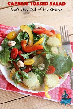 a white plate topped with vegetables on top of a red and white checkered table cloth