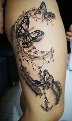 a woman's thigh with butterflies and a dream catcher tattoo on the side of her leg