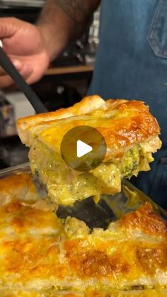 a person holding a spatula in their hand over a casserole dish with broccoli and cheese