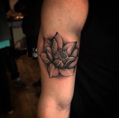 a black and white flower tattoo on the arm