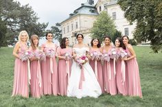 a group of women standing next to each other holding bouquets