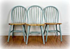 two wooden chairs sitting next to each other on top of a hard wood floor