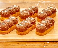 chocolate covered donuts sitting on top of a wooden cutting board