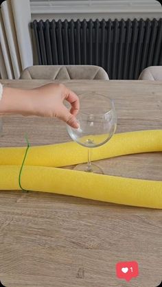 a person is holding a wine glass in front of some yellow tape on a table