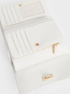 Small in size but big in style, the Huxley front flap wallet in white will help you ace your fashion game while keeping your belongings well-organised. Featuring a sleek curved front flap and knotted gold-toned metallic accent for a chic and sophisticated touch, this accessory is one that you will want to reach for over and over again. Thanks to the push-lock closure and multiple compartments, your belongings are kept safe and secure in this stylish piece. Charles And Keith Wallet, White Wallet, Brand Collaboration, Charles Keith, Mini Wallet, Black Friday Deals, Metallic Accents, Quilting Designs, Fashion Games