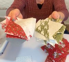 a woman is cutting up pieces of fabric to make christmas decorations with scissors and sewing needles