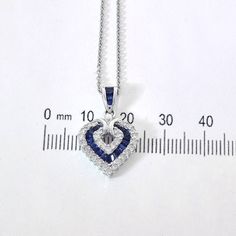 "This marvelous open heart shaped gemstone pendant necklace showcases baguette cut sapphires set in a channel setting & crafted in 14k white gold.The contemporary heart shaped pendant features bright round cut diamonds 0.50 c.t.w., color/clarity G,H-SI alternating with baguette cut sapphires 0.50 c.t.w. Enjoy a matching 14k white gold 18\" long chain with your purchase. Chain secures with lobster claw clasp. Necklace weight is 5.6 grams. For more information, contact Avital & Co Jewelry Sapphire Heart Pendant Jewelry For Anniversary, Heart-shaped Sapphire Necklace For Formal Occasions, Heart-shaped Sapphire Necklace For Formal, Formal Sapphire Heart Pendant Jewelry, Formal Heart-shaped Sapphire Jewelry, Fine Jewelry Sapphire Heart Pendant, Anniversary Sapphire Jewelry With Heart Charm, Sapphire Heart Pendant For Anniversary, Heart-shaped Sapphire Jewelry For Formal Occasions