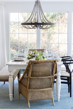 a dining room table with chairs and a chandelier hanging from it's ceiling