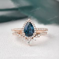 an engagement ring with a pear shaped blue sapphire surrounded by diamonds