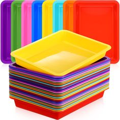 a stack of brightly colored plastic plates and trays with different colors on each plate