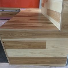 a wooden counter top sitting on top of a hard wood floor next to a red door