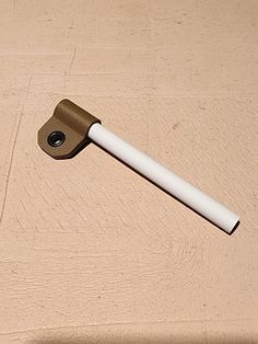 a brown and white object laying on top of a wooden table next to a bottle opener