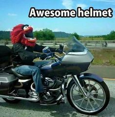 a person riding on the back of a motorcycle with a red wig and face mask