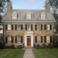 an old brick house with black shutters and white trim