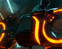 a man riding on the back of a motorcycle with neon lights around his legs and helmet