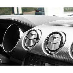 the interior of a car with steering wheel knobs and gauges on it's center console