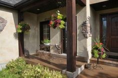 the front porch is decorated with flowers and potted plants