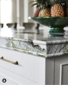 a marble counter top with pineapples in the background