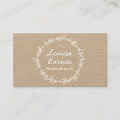 a business card with the words louise barnes on it and a wreath around it