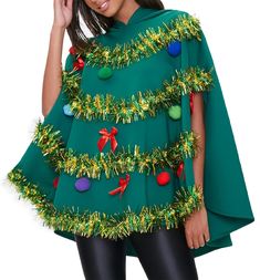 a woman wearing a green christmas tree ponchy cape and black leggings