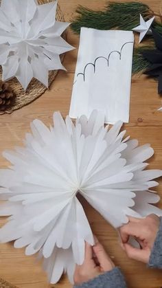 someone is making paper snowflakes on the table