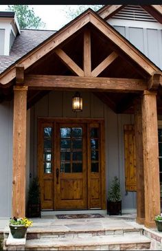 the front entrance to a house with two large wooden doors and steps leading up to it