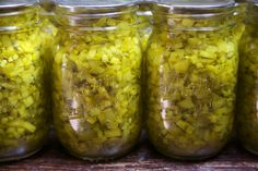 several jars filled with pickles sitting on top of a table