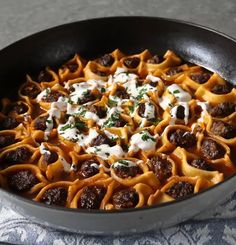 a skillet filled with pasta and meatballs