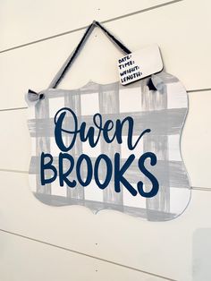 a sign that says oven brooks hanging on the side of a building with wood planks