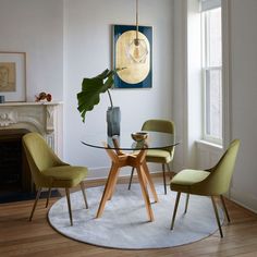 a dining room table with four chairs and a plant in the middle on top of it