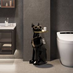 a black cat statue sitting on top of a table next to a white toilet in a bathroom