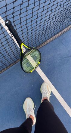 a person standing on a tennis court holding a racquet in their right hand