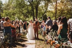 a bride and groom walking down the aisle at their outdoor wedding ceremony, surrounded by guests