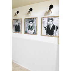 three black and white photos hang on the wall next to two lamps in a room