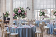 the tables are set with blue linens and pink flowers