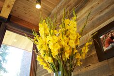 a vase filled with yellow flowers next to a window