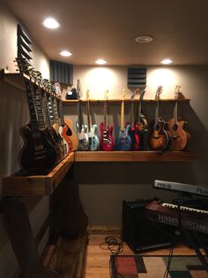 guitars are lined up on shelves in a music studio