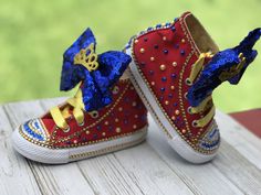 a pair of red shoes with blue and gold sequins on the soles