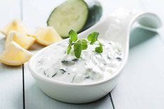 a spoon full of yogurt next to sliced cucumbers