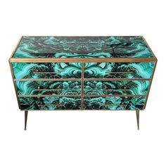 a green and gold dresser with an intricate design on the front, drawers and handles