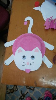 a paper plate with a cat on it sitting on top of a table next to other items