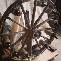 an old wooden wheel with wine bottles in it