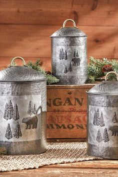 three metal canisters sitting on top of a table