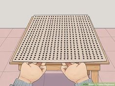 a person sitting at a wooden table with their hands on the top and underneath it